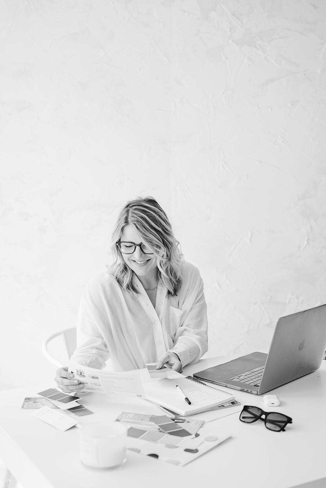 A woman wearing a headset sits at a desk, focused on her work
